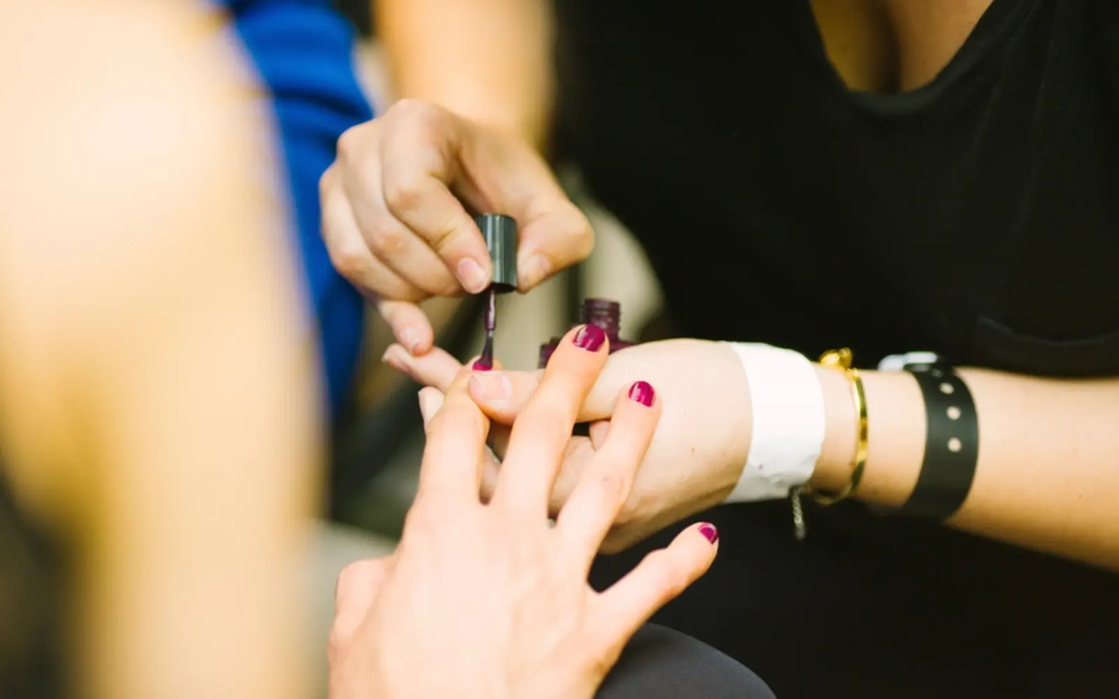 A nail technician painting a client's nails